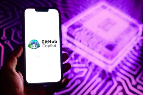 Person holding a phone with the Github logo on the screen