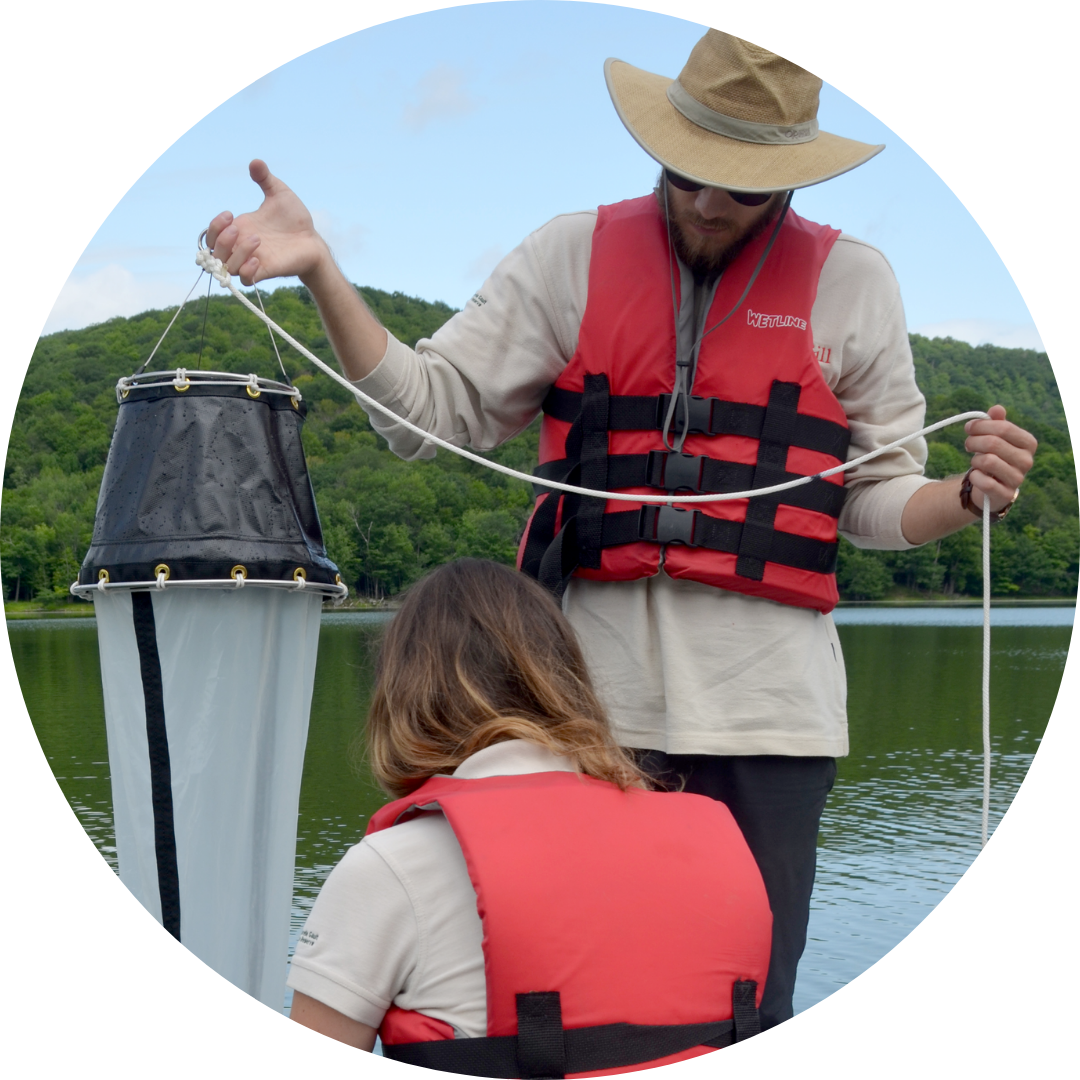 Students in a boat taking samples from the water