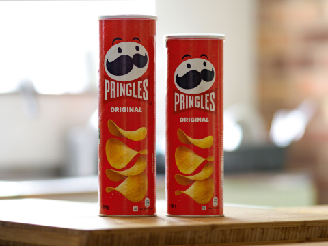 Two Pringles cans next to each other, one larger than the other
