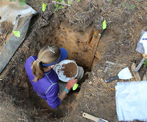 female researcher digging in the soil