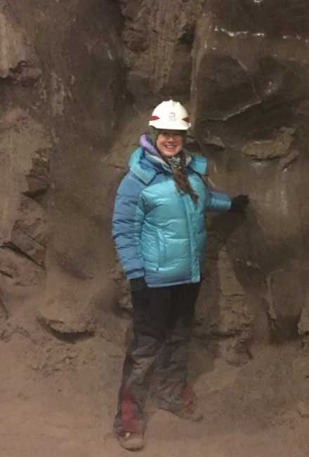 Dr. Mary-Cathrine Leewis standing beside a large dirt wall