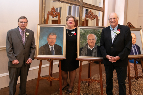 Bruce Coulman and Charles Vincent pose with their official portraits at the Canadian Ag Hall of Fame Gala