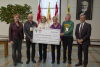 Alumni pose with giant check