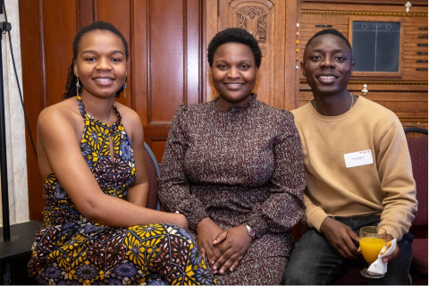 3 Mastercard Foundation Scholars seated together, smiling.