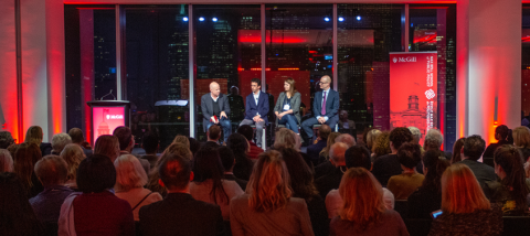 view of a 2018 Max Bell School event with four people on center stage and an audience looking on