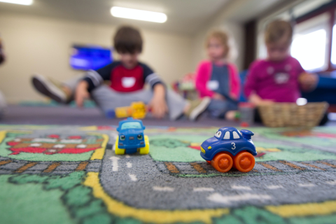 Children play with toys cars in a daycare