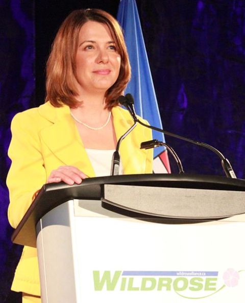 a photo of Danielle Smith giving a speech in a stand