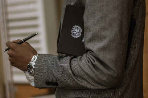 A person holds a binder bearing the United Nations logo