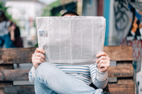 A person reads a newspaper