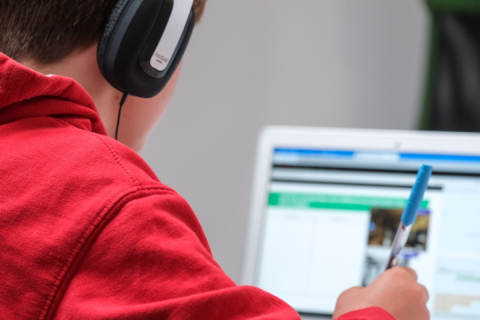 A young person does work using a laptop