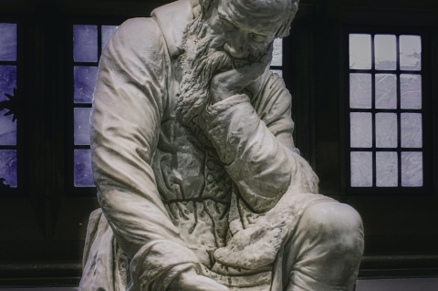 an image of the sculpture of a man who is sitting with his left hand supporting his face