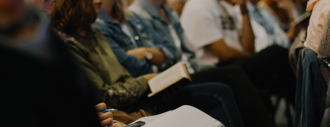 view of random peoples laps, seated in a row at an event