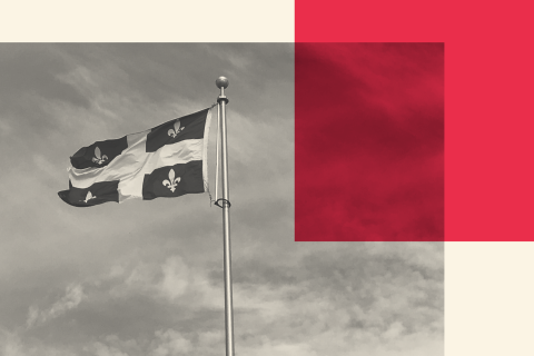 A Quebec Flag waves in the wind with a red square