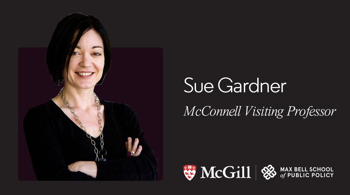 Sue Gardner smiling with arms crossed in black shirt on black backdrop