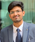 Siril Teja Dukkipati in a suit and tie smiling at camera 