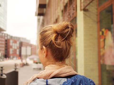 Photo of back of girl's head as she walks through European street