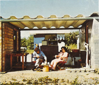 A couple sit in front of the ECOL house