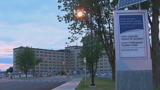 View of a hospital and parking lot at dusk.