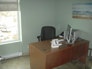 An office with a table, chair, and computer.