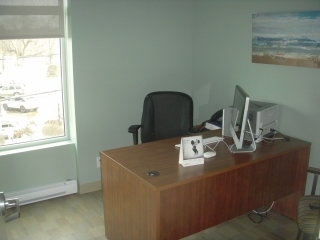 Un bureau avec chaise, table, et ordinateur.