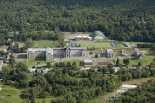 Aerial view of some buildings and patches of forest.