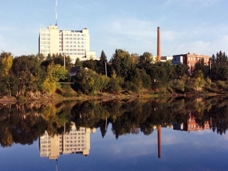 Body of water with trees and buildings in the background.