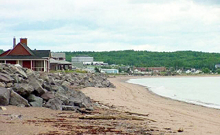 A beach with water and buildings.