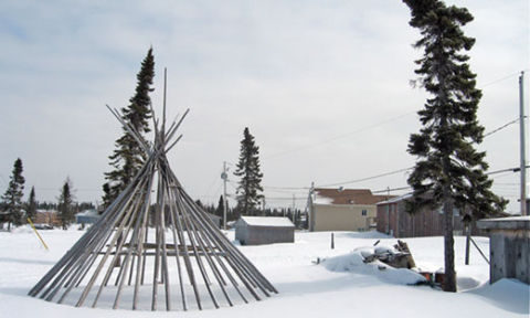 The infrastructure of a tipi in the snow.