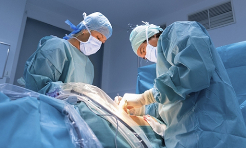 Two doctors in an operating room doing a surgery.