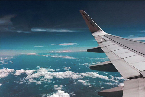 l'aile d'un avion dans le coin droit, avec un ciel bleu en arrière-plan