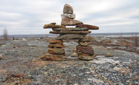 An inuksuk (inuit sculpture) on a rock.