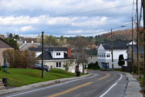 Une route dans la ville de Saint Andre Avellin, QC avec des maisons.