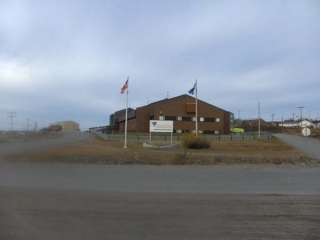 A building with grass and two flags.