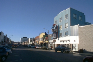 A road with a blue building on the right.