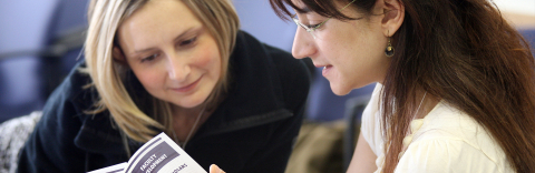 Two McGill employees look at Faculty Development flyer