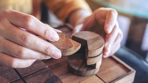 Hands working on a block puzzle