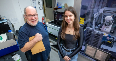 Terry Hébert et Giada Castagnola debout devant le nouveau microscope de pointe de leur laboratoire.