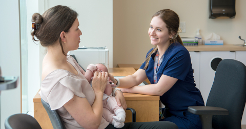 Une résidente en médecine de famille discute avec une nouvelle maman qui tient son poupon dans ses bras.