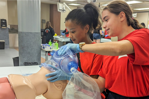 High school students working on a simulated manikin