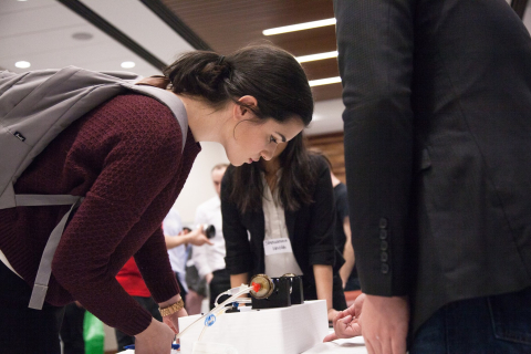 Student looking at a project done by another team during an event displaying student projects