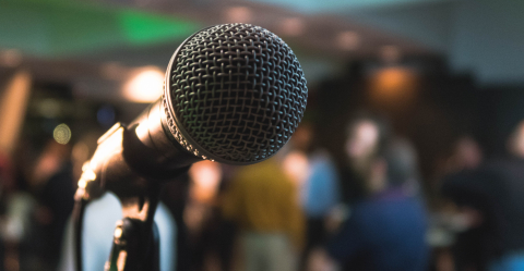 Close up of microphone with people blurred in background