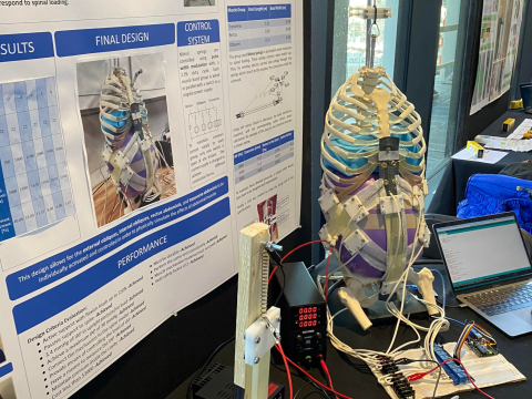 Poster for additional abdomens to robotic spine and model of robotic spine on right with laptop