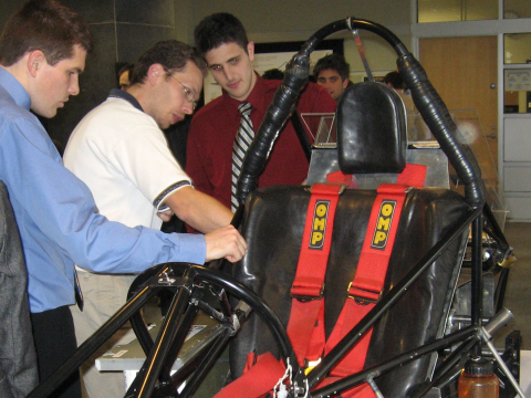 Students and judge reviewing a racecar seat at McGill Design Day