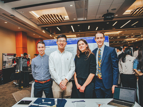 Four students standing in front of their design project at McGill Design Day