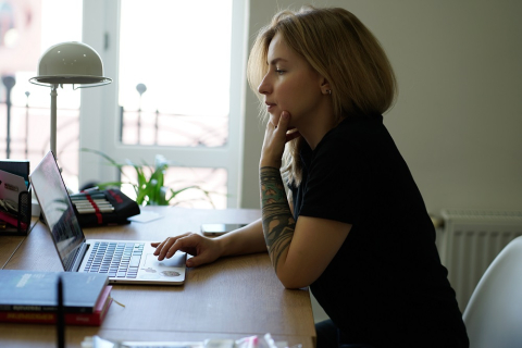 Student looking pensive while looking at laptop screen