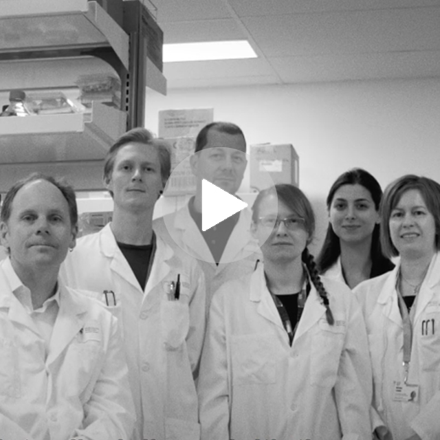 6 lab members wearing lab coats standing in a line