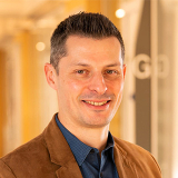 Mathieu Bourgey wearing a suit, smiling
