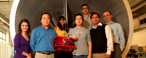professor tim lee with students in front of wind tunnel