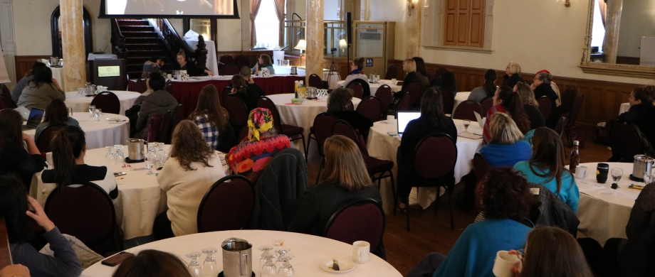 People sitting around multiple tables in a conference