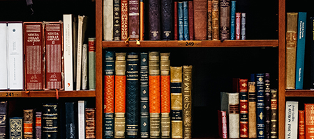 Old books stacked in library shelves.